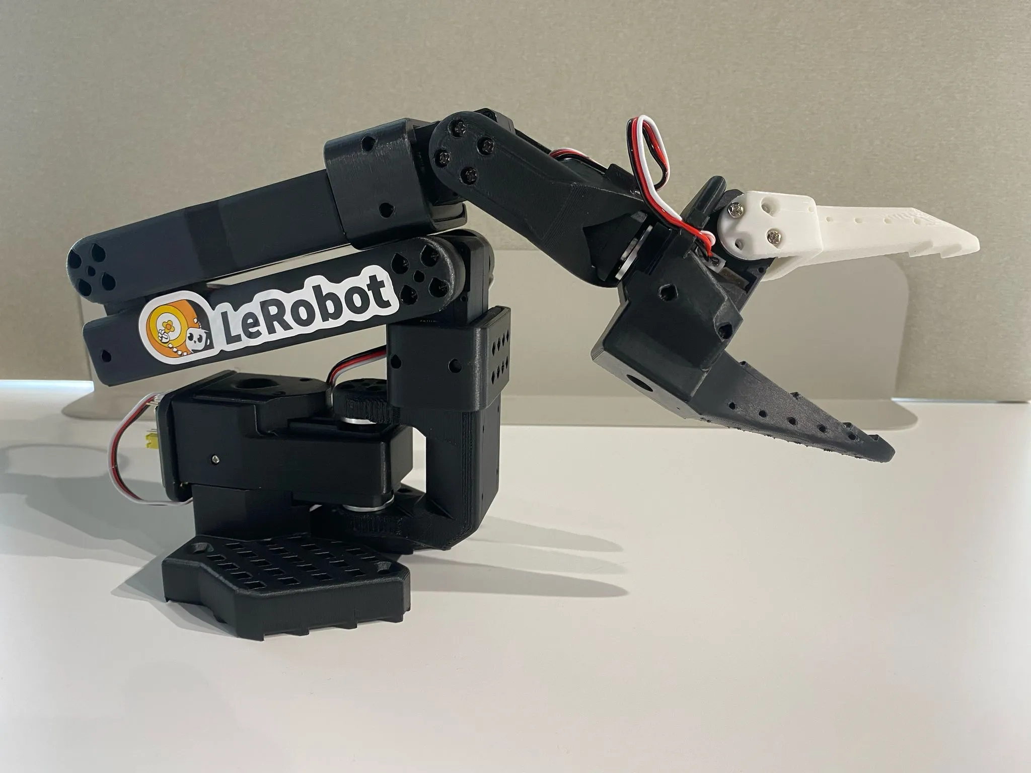SO-101 follower arm: a white 3D-printed 6-axis arm with a gripper